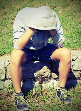 gri hoodie ve vintage etkisi ile spor ayakkabıları çok depresif bir çocuk