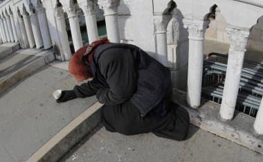 bir siyah ceket ve sadaka için bir köprü üzerinde soran başında bir şal ile eski çingene kadın