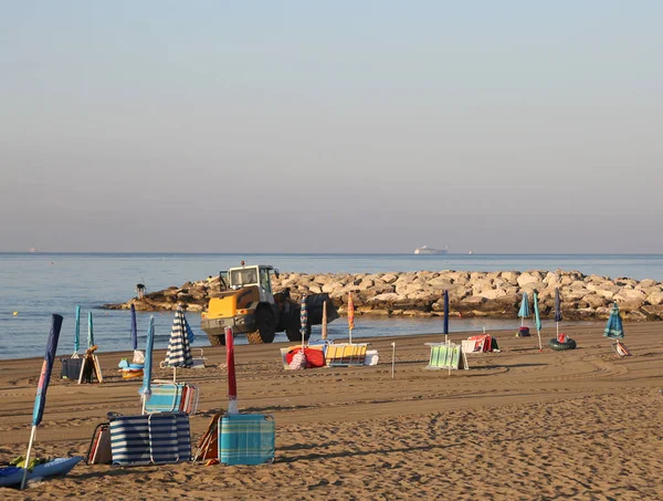 Spiaggia Con Ombrelloni Sdraio Mattina Presto Trattore Che Pulisce Sabbia — Foto Stock