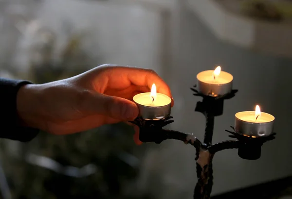 在教堂点燃蜡烛的信徒的手 以纪念死者亲属 — 图库照片
