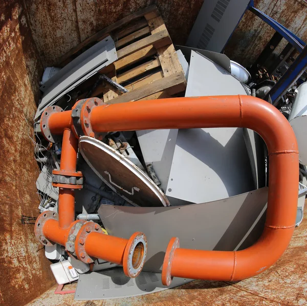 巨大的橙色管子在容器与许多用尽的材料 — 图库照片