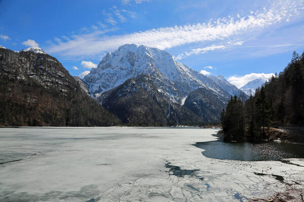 Ледовое альпийское озеро под названием Лаго-дель-Предил в Италии недалеко от Тарвизио и гор зимой

