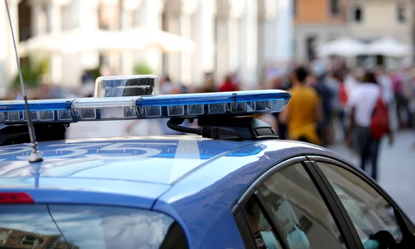 Police car with blue sirens in the main square of the city