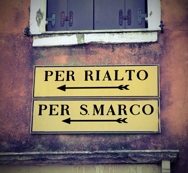 Venice in Italy and the italian road sign to go to Saint Mark square or Rialto Bridge with vintage effect