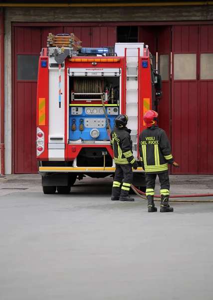 イタリア イタリア 2018 火災のトラックや つ行きません消防消防署の兵舎でイタリア語で消防士を意味するテキスト Vigili Del Fuoco の制服 リーダーである赤いヘルメットと消防士 — ストック写真