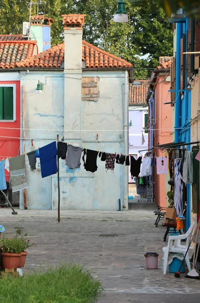 laundry clothes hung out to dry between two houses in a small square of Burano