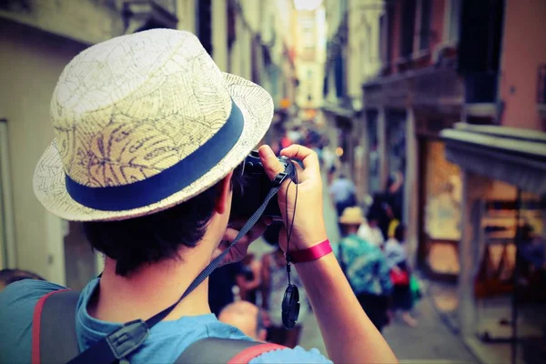 デジタル カメラの少年はヴィンテージの古い効果とイタリアのヴェネツィアでイタリア語で狭い通りと呼ばれる通りの多くの写真を取る — ストック写真