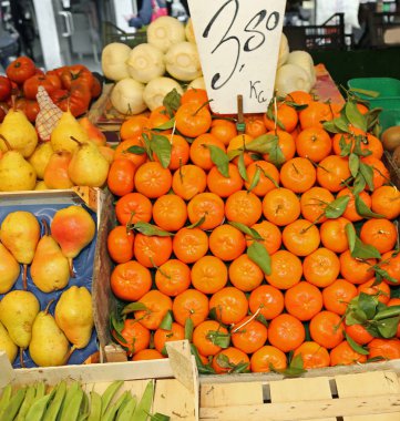 bir manav kilo fiyatı işaretiyle tezgahın üzerine portakal mandalina kutu
