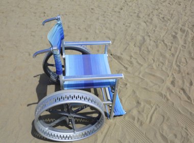 plajın kumları üzerinde kolayca taşımak için büyük tekerlekleri ile özel tekerlekli sandalye