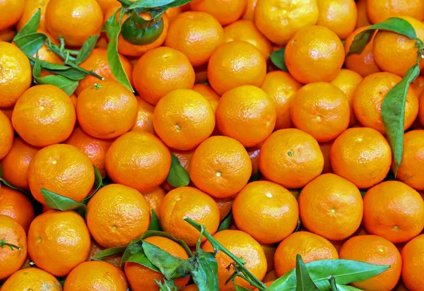 background of small orange mandarins from Sicily for sale in a fruit and vegetable shop