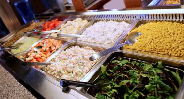 marul Mısır Rus salatası ve diğer yemekler self servis restoran birçok tepsileri ile dolu
