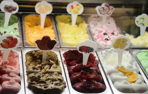 many flavors of ice cream on sale in the window of the Italian ice cream parlor in the summer