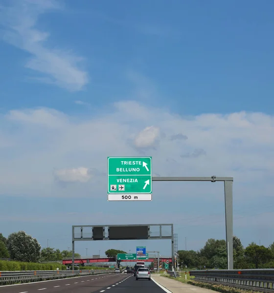 Big road sign on the highway with directions to go to Italian cities called Trieste Belluno or Venice