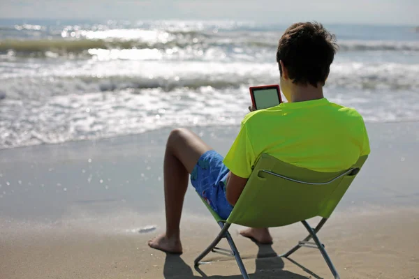 Teenager Reads Digital Book Sitting Folding Chair Front Sea — Stock Photo, Image