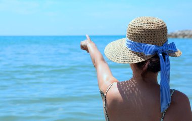 ufuk yaz aylarında hasır şapka olan kadın gösterir