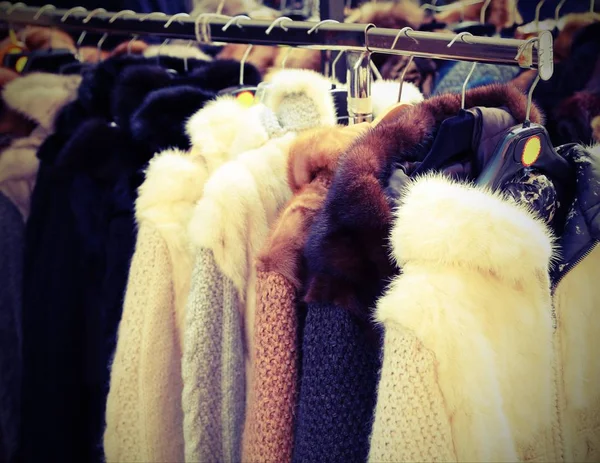 many vintage clothes and fur for sale at flea market with vintage effect