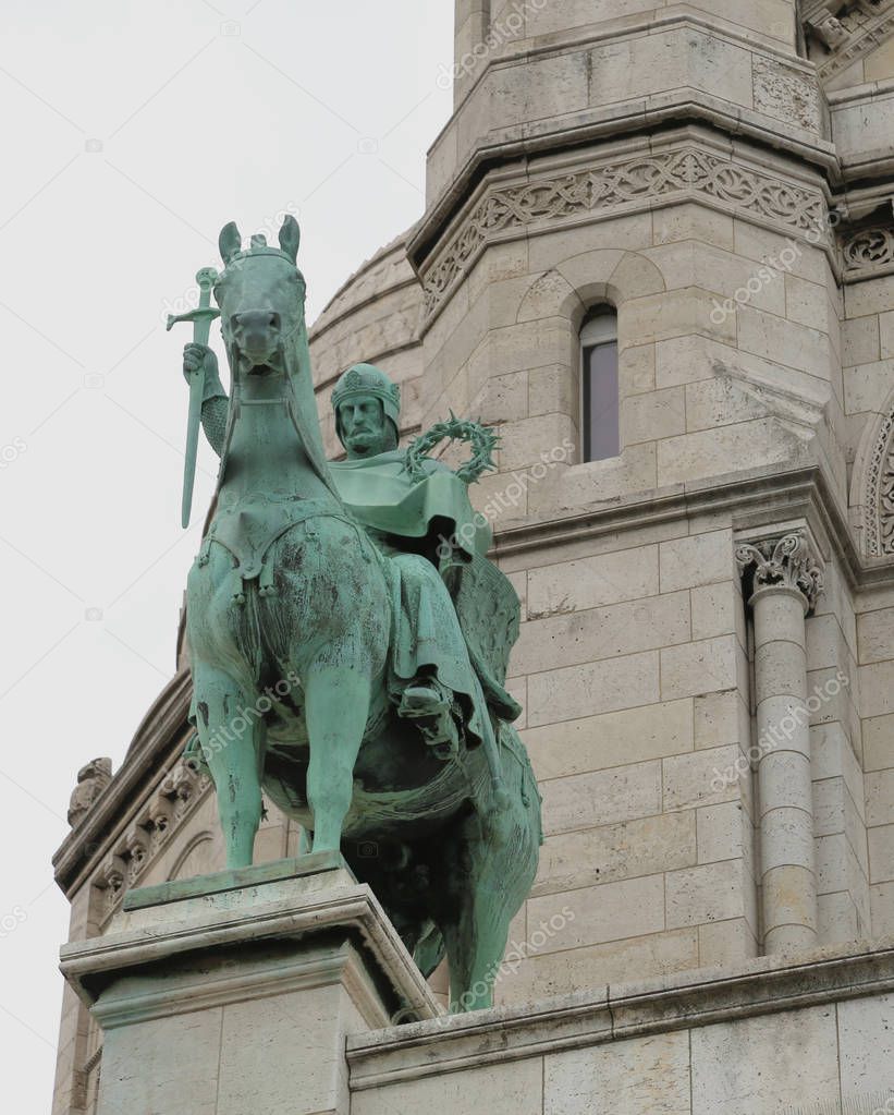 big statue of King Saint Louis and the Basilica of Sacred Heart in Paris  France