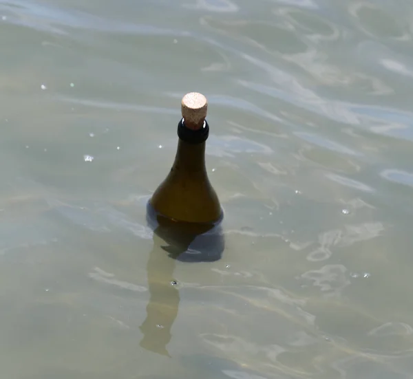one bottle with secret message floats on the water of the sea