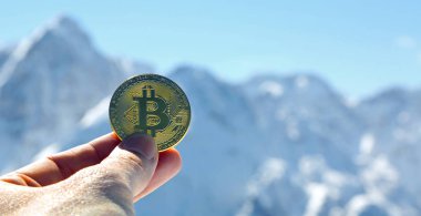 bir adamın elini bitcoin para ve dağ zemin üzerine altın sikke