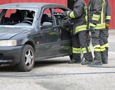 Italia, İtalya - 10 Mayıs 2018: İtalyan itfaiyeciler yaralı arabadaki yol kazadan sonra ücretsiz için makası kullanın