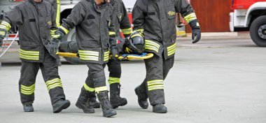 Italia, İtalya - 10 Mayıs 2018: İtalyan porter itfaiyeciler yaralı bir sedye üzerinde pratik kurtarma egzersiz sırasında taşıma