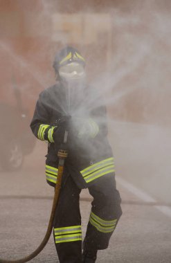 Italia, İtalya - 10 Mayıs 2018: İtalyan itfaiyeci üniforması ve kask ile hidrant köpük ile itfaiye bir egzersiz sırasında kullanır