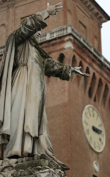 Big statue of Savonarola Girolamo in Ferrara in Italy and the clock tower