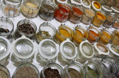 Satılık Ahşap arka plan üzerinde birçok kavanoz baharatlar ile. Gıda