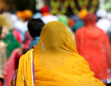 Sih kadın saçlarını turuncu bir örtü ile dini bir olay sırasında kapsar.