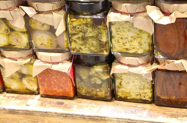 glass jars with Calabrian specialties such as spicy broccoli onions fish in oil for sale in the specialty store of Southern Italy
