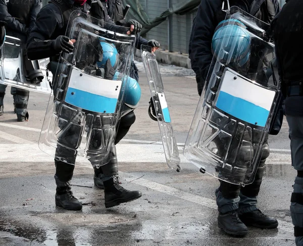 many policemen with shields and riot gear during the sporting event