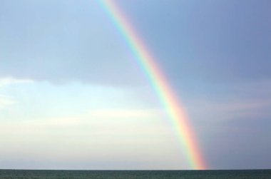 gerçek gökkuşağı sonra okyanus ve mavi gökyüzü arka plan üzerinde fırtına