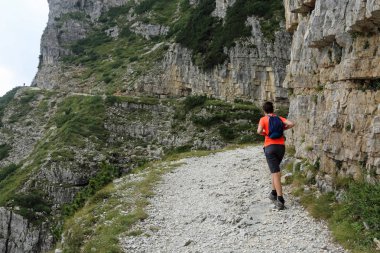 Çocuk bir dağ iz üzerinde bulutlu bir günde yürür.