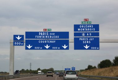 big road signs on the busy French highway to go to Paris and to the other indicated locations clipart