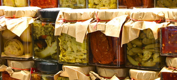 glass jars with spicy specialties typical of southern Italian regions suche as green broccoli tomatoes peppers and  preserved under olive oil