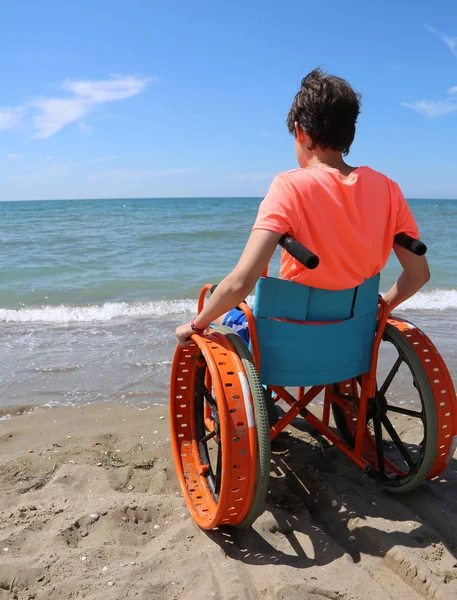 Yaz Aylarında Kumsal Denizden Küçük Çocuk Tekerlekli Sandalyede Bakar — Stok fotoğraf