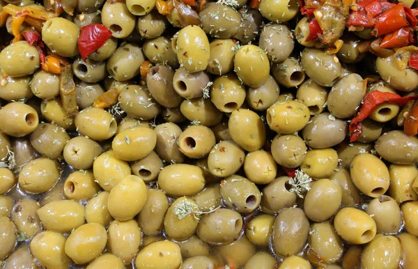 在意大利南部的意大利食品展台上出售的绿色腌制橄榄和一些红辣椒 — 图库照片