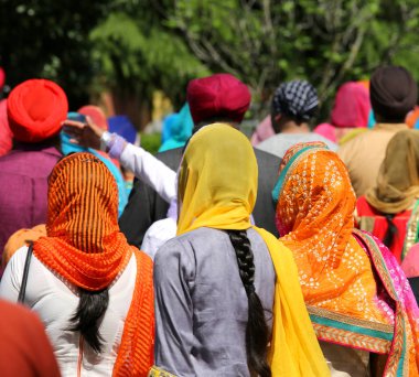 Açık dini geçit töreni sırasında renkli bir perde ve bazı kendi saç uzun örgüler ile başlarını birçok kadın kaplı