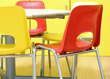 msall red and yellow chairs in the classroom of a kindergarten without children