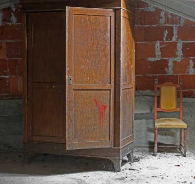 Eski bir ahşap dolap ve eski bir sandalye ile kasvetli tavan