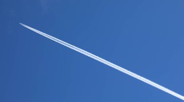 Motor egzoz contrails mavi gökyüzünde bir uçağın arkasında şekillendirme