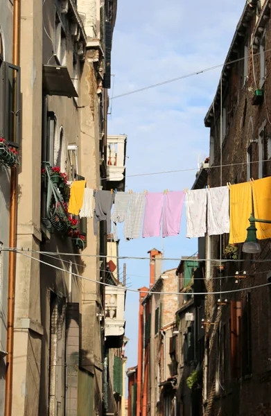 many clothes hanging out to dry between two houses in the European town