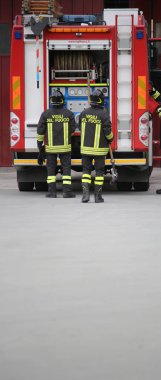 Vicenza, VI, İtalya - 10 Mayıs 2018: iki üniformalı İtalyan itfaiye eri ve metin itfaiyeciler İtalyan dilinde sırasında pratik yol kenarında demek Vigili del fuoco egzersiz kurtarma