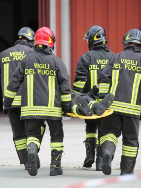 Vicenza, VI, İtalya - 10 Mayıs 2018: sedye taşıyıcılar itfaiyeciler yaralı bir sedye üzerinde pratik kurtarma egzersiz sırasında taşıma