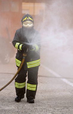 Vicenza, VI, İtalya - 10 Mayıs 2018: İtalyan itfaiyeci hidrant köpük ile itfaiye bir egzersiz sırasında kullanır