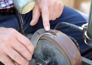 Taşlama tekerleği kullanarak eski bir bill kesici bıçak bıçak bileyici keskinleştirir