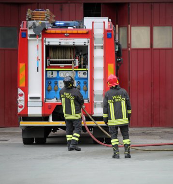 Roma, Rm, İtalya - 10 Mayıs 2018: iki İtalyan itfaiye itfaiyeci İtalyan dilinde bir pratik egzersiz sırasında demek metin Vigili del fuoco üniformayla ile. Kırmızı kask ile itfaiyeci lideridir