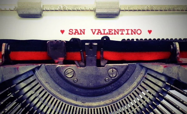 text by typewriter Saint Valentine and two red hearts with vintage toned effect
