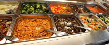 Fasulye ve mantar ve brokoli gibi birçok çiğ ve pişmiş gıdalar ile içinde bir self servis restoran