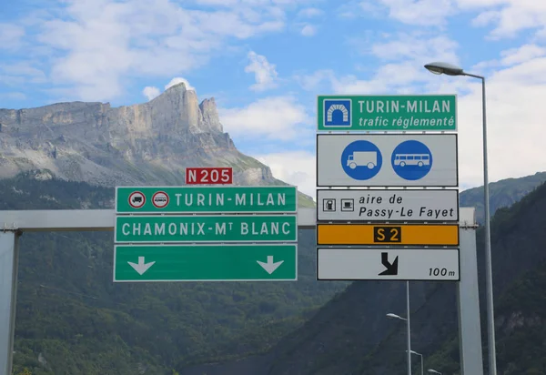 road sign on the border between Italy and France with directions to go to Turin Milan using the motorway tunnel